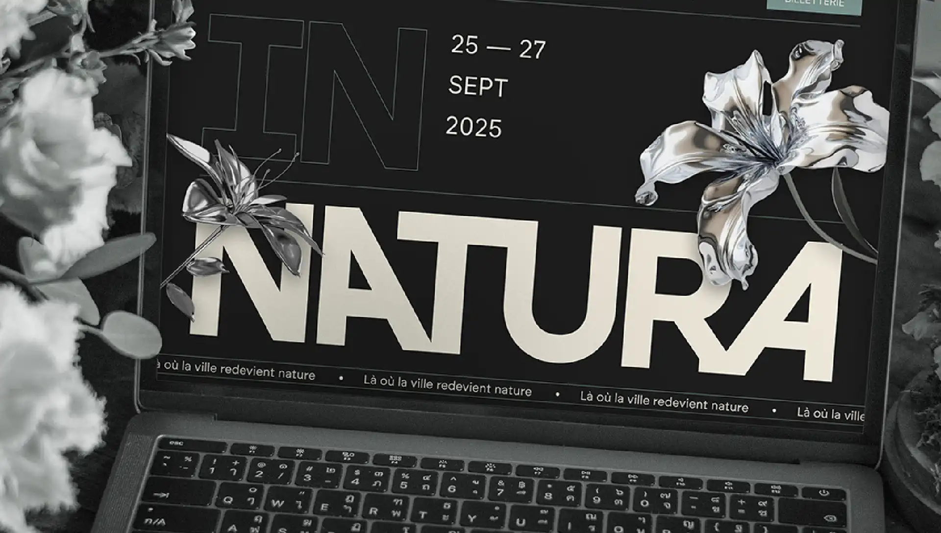Mise en scène de la page d'accueil du site In Natura sur un laptop au milieu des fleurs