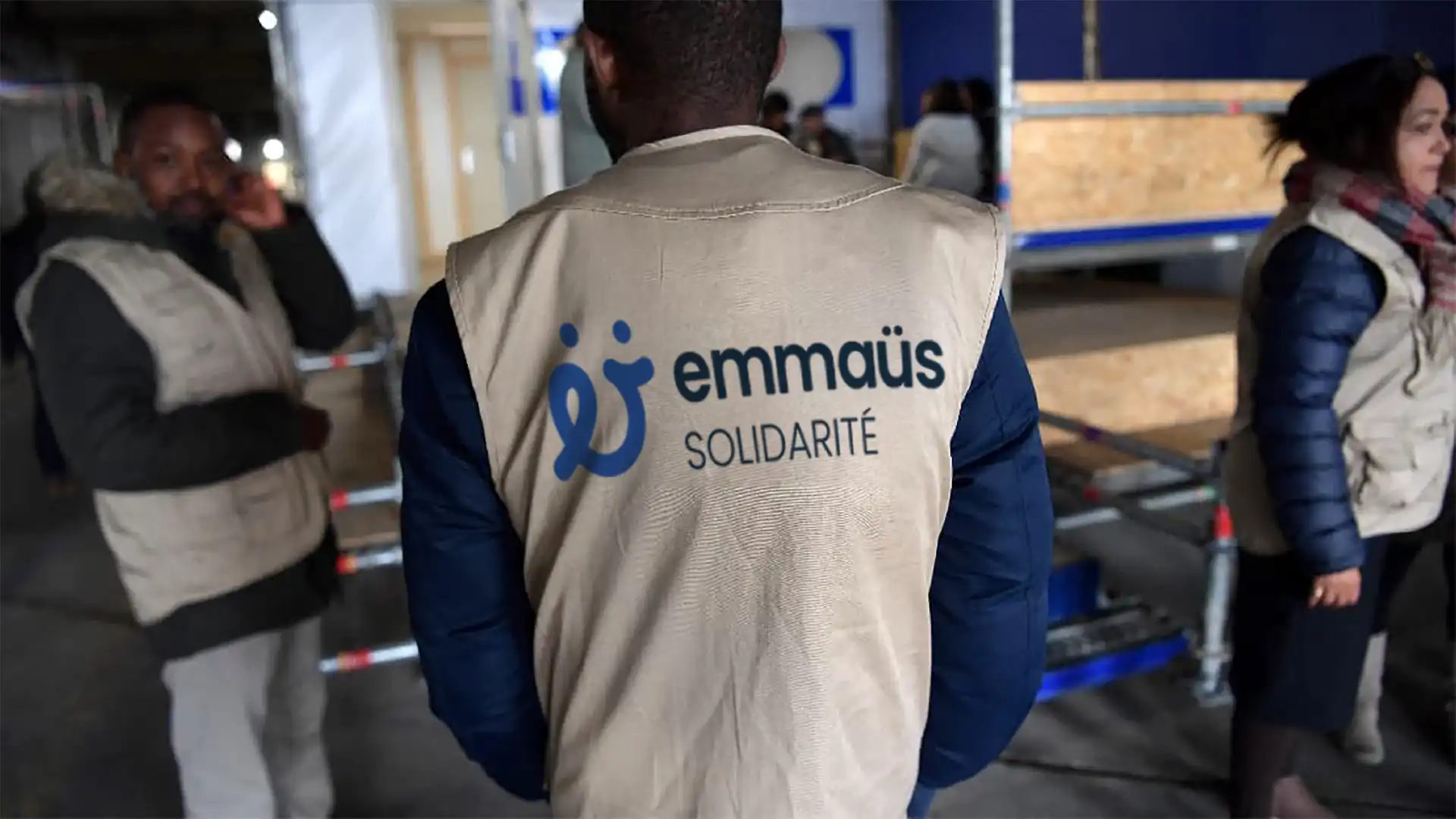 Photo retouchée d'un bénévole de dos avec un gilet floqué Emmaüs Solidarité