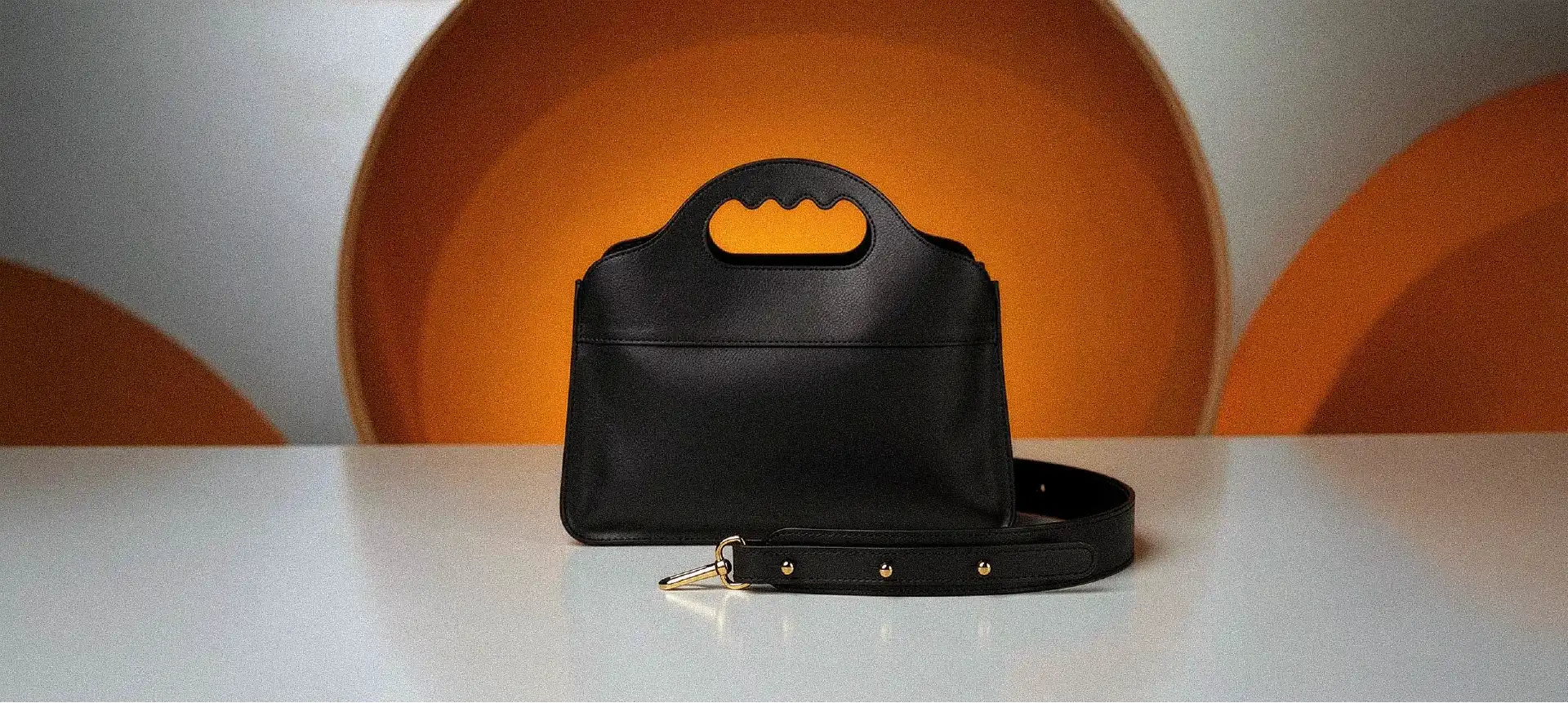 Un sac Lua centré posé devant un décor rétro orangé