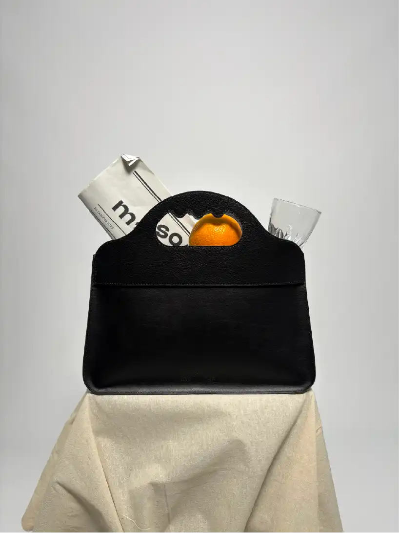 Photoshoot d'un sac Lua contenant un journal et une orange
