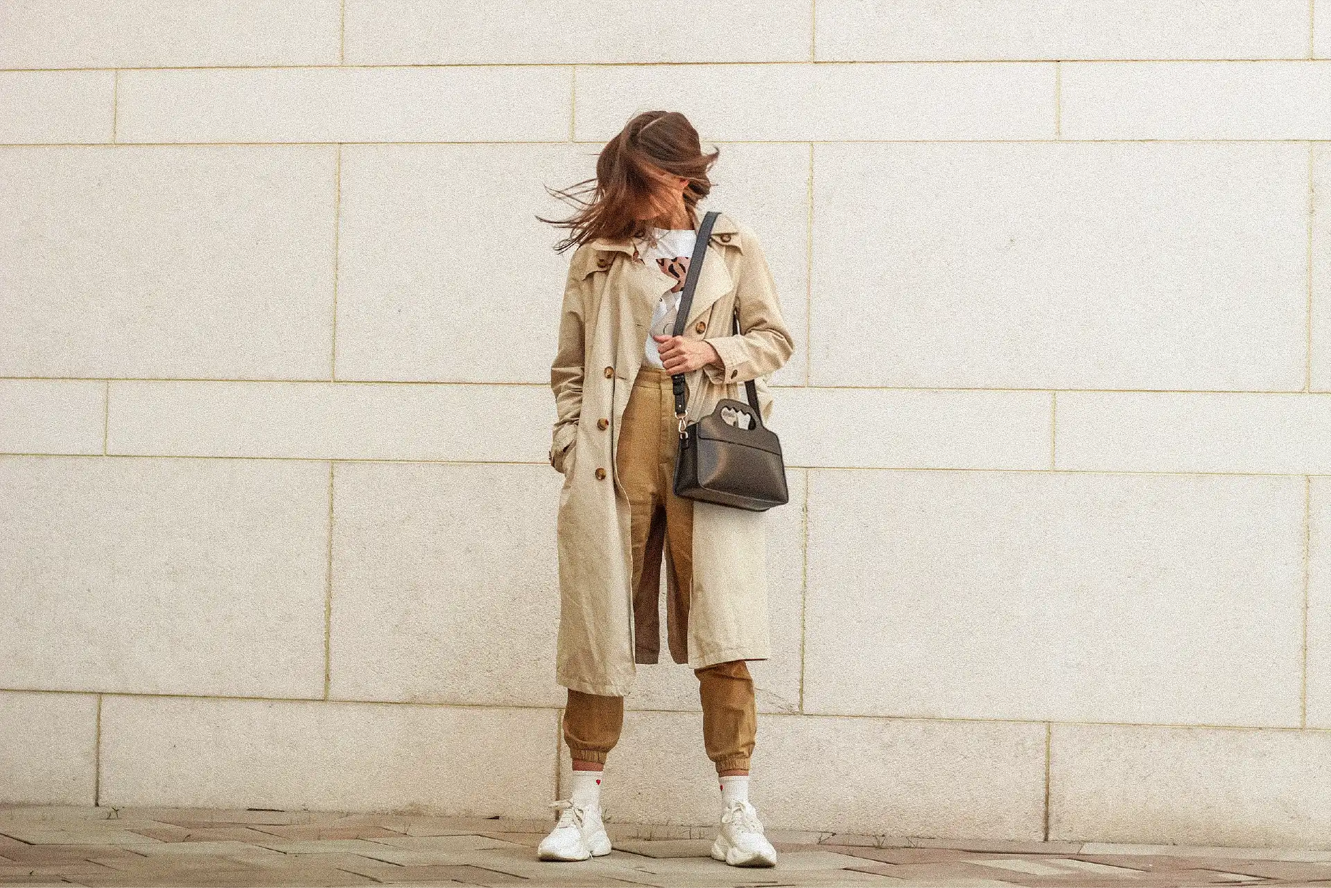 Femme portant un Lua posant devant un mur blanc